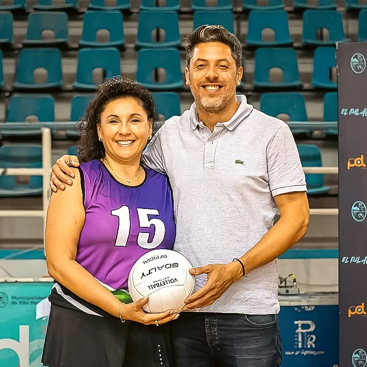 Nicolás González Ferro junto a una deportista con una pelota de vóley